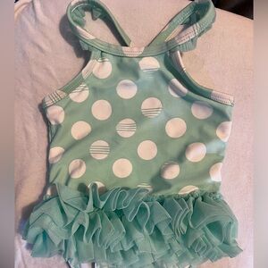 Toddler girls bathing suit. Snap closure at bottom. Ruffle/tutu on waist & arms